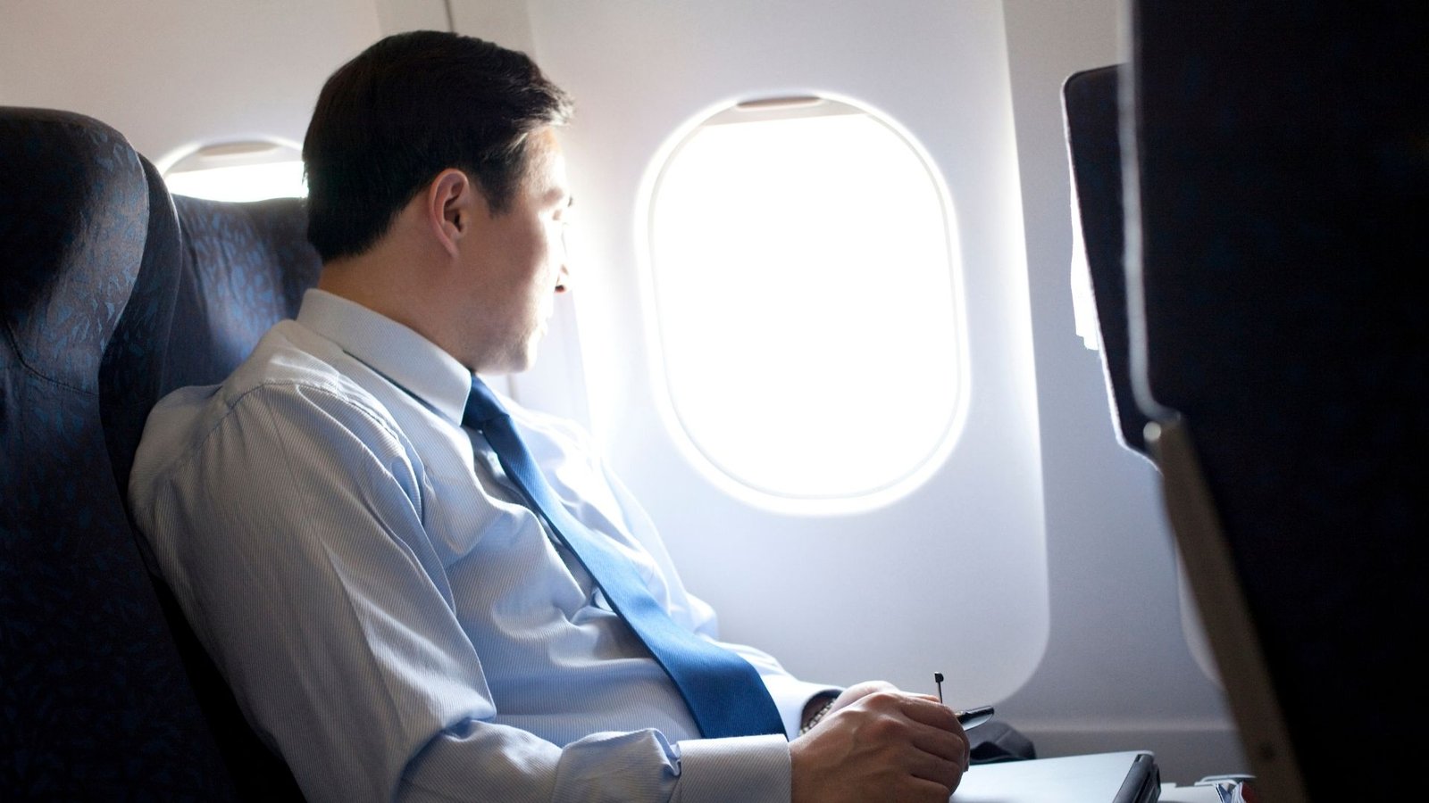 Quiet traveller looking out from an airplane window